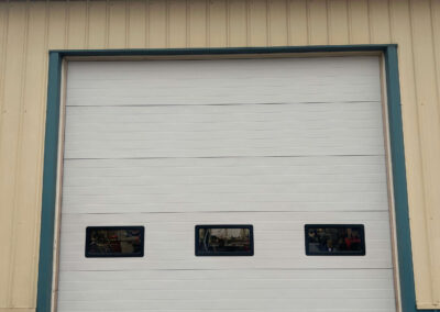 Armstrong Tractor - A white garage door with two windows.