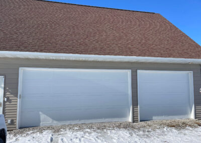 A garage with a white roof and a white garage door.