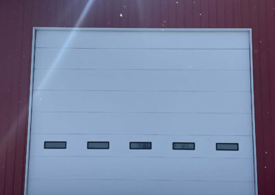 Hassenclever - A red barn with a white garage door.