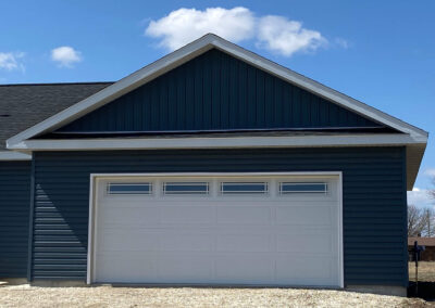 A blue house with a white garage door.