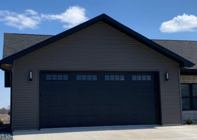 A house with a black garage door.