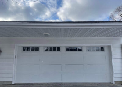 A white garage door with a white roof.