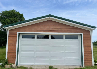 A white garage with a green door.