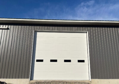 MELLINGER - a gray garage door with a blue sky behind it.