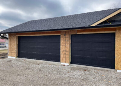Nelson - black garage door in a house that is under construction.