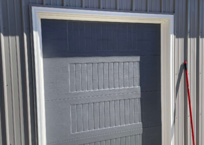 A gray garage door with a red broom.