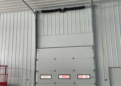 A storage door in a metal building with a ladder.